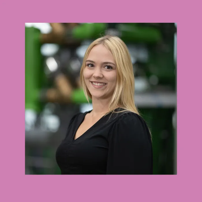 Portrait von Alexandra. Sie hat blonde Haare, braune Augen und lächelt. Sie trägt eine schwarze Bluse und ist geprüfte Personalfachkauffrau.