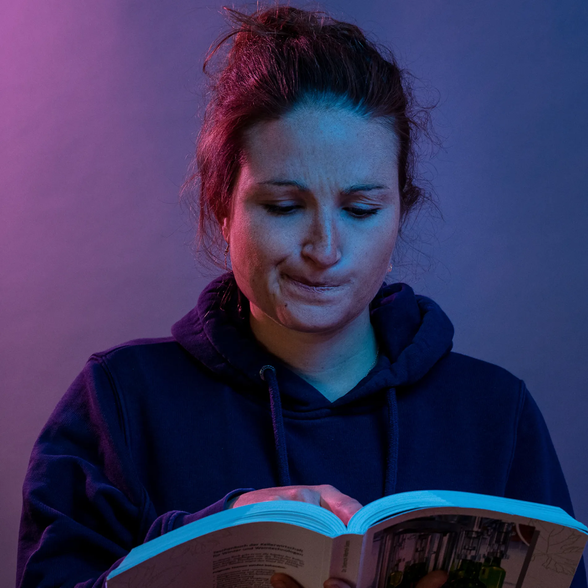 Aufsteiger-Botschafterin Marie hält ein Buch in der Hand und denkt nach.